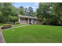 Inviting home featuring a classic front porch, lush green lawn and mature shady trees at 6 Water View Dr, Stockbridge, GA 30281