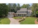 Stately home with a stone driveway and professionally landscaped front yard and a three car garage at 585 Old Cobblestone Dr, Atlanta, GA 30350