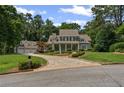 Beautiful home with lush landscaping, stone accents, and a long driveway leading to a three-car garage at 585 Old Cobblestone Dr, Atlanta, GA 30350
