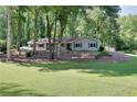 Well-manicured front lawn and mature trees surround this charming single-story home at 1379 Branchwood Dr, Snellville, GA 30078