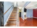 Inviting entryway with hardwood stairs, wood floors, and a view into the living room featuring a fireplace at 5292 Windfield Glen Nw Ct, Lilburn, GA 30047