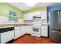 Functional kitchen with white cabinets, granite countertops, and essential appliances at 5292 Windfield Glen Nw Ct, Lilburn, GA 30047