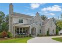 Gorgeous stone home featuring a covered front porch, well manicured lawn, and lovely landscaping at 126 Owens Mill Pl, Canton, GA 30115
