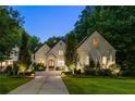 Beautiful two-story home at dusk with lush landscaping, elegant lighting, and an inviting arched wooden front door at 803 Courtenay Ne Dr, Atlanta, GA 30306