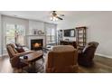 Cozy living room with a fireplace, hardwood floors, and lots of natural light at 113 Regent Pl, Woodstock, GA 30188