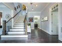Elegant foyer with hardwood floors, a staircase with iron railings, and stylish decor at 1075 Bluffhaven Way Northeast Ne Way, Atlanta, GA 30319