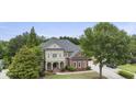 Aerial view of a brick two-story home with a columned front porch nestled among mature trees at 1565 Briergate Dr, Duluth, GA 30097