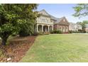 Elegant two-story brick home with a columned front porch and well-manicured lawn and professional landscaping at 1565 Briergate Dr, Duluth, GA 30097