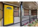 Inviting covered front porch with a bright yellow door, decorative railing, and fresh landscaping at 2760 Swansea Ct, College Park, GA 30349