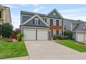 Inviting two-story home featuring a brick facade, blue siding, a well-manicured lawn, and a spacious two-car garage at 4312 Shillham Ct, Cumming, GA 30040
