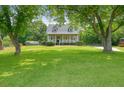 Traditional home with a large front yard, mature trees, and a welcoming front porch at 117 Village Ct, Woodstock, GA 30188