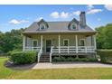Charming home with a covered front porch, white railings and columns, and a well-maintained lawn at 117 Village Ct, Woodstock, GA 30188