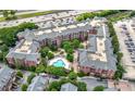 Aerial view of a red brick condo complex featuring a pool, parking, and mature trees at 1735 Peachtree Ne St # 316, Atlanta, GA 30309