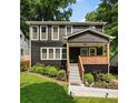 Charming two-story home with dark siding, a cozy porch, and well-maintained landscaping at 1558 Line St, Decatur, GA 30032