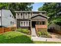 Charming two-story home features a welcoming front porch, complemented by lush landscaping and a green lawn at 1558 Line St, Decatur, GA 30032