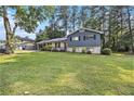 Well-maintained two-story home with a lush green lawn and mature trees at 6085 Dunbritan Ln, Atlanta, GA 30349