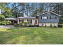 Charming two-story home with a well-manicured lawn and a covered carport at 6085 Dunbritan Ln, Atlanta, GA 30349