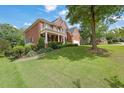 Charming brick residence showcasing a lush green lawn and mature trees at 6260 Sturbridge Ln, Cumming, GA 30040