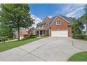 Traditional brick home with a long driveway, attached garage, and well-maintained landscaping at 6260 Sturbridge Ln, Cumming, GA 30040