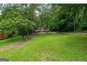 Sprawling green backyard surrounded by mature trees offers space for outdoor activities and recreation at 243 Howell Ter, Atlanta, GA 30331