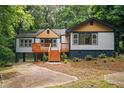 Inviting home with wood deck, steps and lots of natural light, nestled in a green, leafy setting at 243 Howell Ter, Atlanta, GA 30331