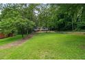 Spacious front yard leads to a charming house surrounded by lush greenery at 243 Howell Ter, Atlanta, GA 30331