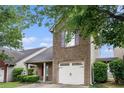 Inviting brick home featuring an attached one-car garage and well-maintained greenery at 222 Ben Ln, Fairburn, GA 30213