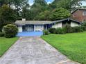 Charming single-story home with blue accents, a unique driveway, a well-maintained front yard at 2323 Valleyside Dr, Decatur, GA 30032
