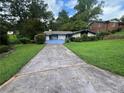 Charming single-story home with blue accents, a unique driveway, a well-maintained front yard at 2323 Valleyside Dr, Decatur, GA 30032