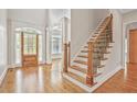 Bright foyer boasts hardwood floors, staircase with iron spindles, and detailed trim at 5513 Lavender Farms Rd, Powder Springs, GA 30127