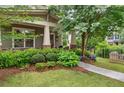 Lush front yard featuring beautiful landscaping, complemented by a charming covered porch with cozy seating at 1184 Medlin Se St, Smyrna, GA 30080