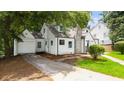 Charming home exterior with attached garage and driveway surrounded by mature trees at 1366 Allegheny Sw St, Atlanta, GA 30310