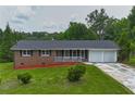 Charming one-story brick home with manicured lawn and attached two-car garage at 5488 Janice Ln, Stone Mountain, GA 30087