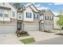 Attractive townhome showcasing stone accents, a well-kept lawn, an attached garage, and stylish architectural details at 1363 Cooper Springs Rd, Grayson, GA 30017