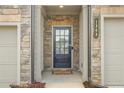 Inviting front entrance with a black door framed by stone accents and featuring house number signage at 1363 Cooper Springs Rd, Grayson, GA 30017