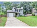 View of the charming two-story home with a one-car garage on a well-maintained lawn at 3130 Glen Knolls Ct, Alpharetta, GA 30022