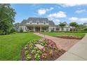 Stunning two-story home with a lush green lawn, beautiful landscaping, and a charming brick walkway at 710 Cox Rd, Roswell, GA 30075