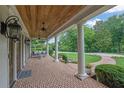 Spacious front porch featuring brick flooring, ceiling fans, and an outdoor seating area at 710 Cox Rd, Roswell, GA 30075
