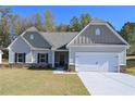 Charming one-story home boasts a two-car garage, stone accents, complemented by a well-manicured lawn at 490 Charleston Pl, Villa Rica, GA 30180