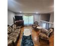 Living room with hardwood floors, decorative fireplace, traditional furniture, and window at 976 Bakers Bridge Rd, Douglasville, GA 30134