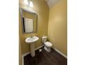 Cozy half bathroom featuring a pedestal sink, toilet and modern fixtures and hardware at 102 Daisy Cir, Mcdonough, GA 30252
