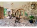Inviting covered porch with brick flooring, rocking chairs and arched doorways at 3146 Frontenac Ne Ct, Atlanta, GA 30319