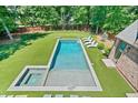 Aerial view of a backyard with a rectangular pool, integrated hot tub, and lounge area at 3146 Frontenac Ne Ct, Atlanta, GA 30319