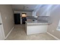 Kitchen featuring white cabinets, black appliances, and light granite countertops at 3679 Seabass Rd, Decatur, GA 30034