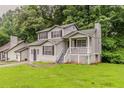 Two-story home boasts a charming front porch, well-maintained lawn, and inviting curb appeal at 6114 Leverett Dr, Lithonia, GA 30038