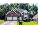 Charming two-story brick home with well-manicured lawn and attached two-car garage at 6385 Southland Forest Dr, Stone Mountain, GA 30087