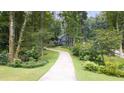 Long driveway leading to a charming home surrounded by mature trees and landscaping at 1880 Doefield St, Canton, GA 30115