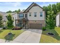 Charming two-story home features a stone and shingle facade, well-manicured lawn, and an attached two-car garage at 4568 Mantova Dr, Buford, GA 30519