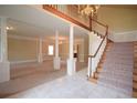 Spacious living room with pillars, neutral carpet, chandeliers and a staircase at 830 Cramac Dr, Lawrenceville, GA 30046