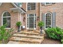 Charming front porch with stone steps, elegant planters, and brick facade at 120 Forest Breeze Cv, Alpharetta, GA 30022
